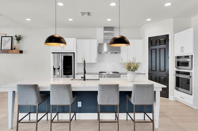 3850 Bonfire Dr, Odessa, FL 33556 - kitchen featuring stainless steel appliances, wall chimney range hood, a sink, white cabinetry, and tasteful backsplash