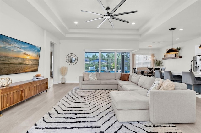 3850 Bonfire Dr, Odessa, FL 33556 - living room featuring a tray ceiling, light wood-type flooring, recessed lighting, ceiling fan, and baseboards