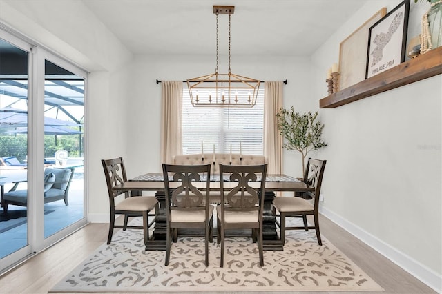 3850 Bonfire Dr, Odessa, FL 33556 - dining space with a chandelier, light wood finished floors, and baseboards