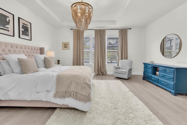 3850 Bonfire Dr, Odessa, FL 33556 - bedroom featuring light wood-style floors, a chandelier, a raised ceiling, and baseboards