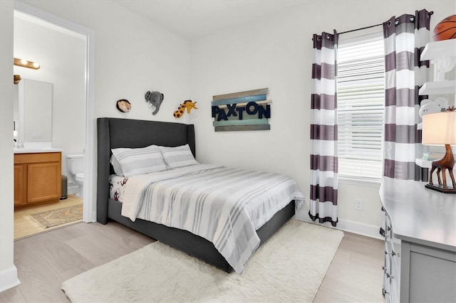 3850 Bonfire Dr, Odessa, FL 33556 - bedroom featuring ensuite bathroom, light wood finished floors, baseboards, and a sink