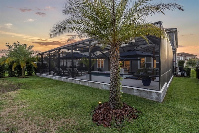 3850 Bonfire Dr, Odessa, FL 33556 - back of property at dusk with a patio area, a lawn, an outdoor pool, and a lanai