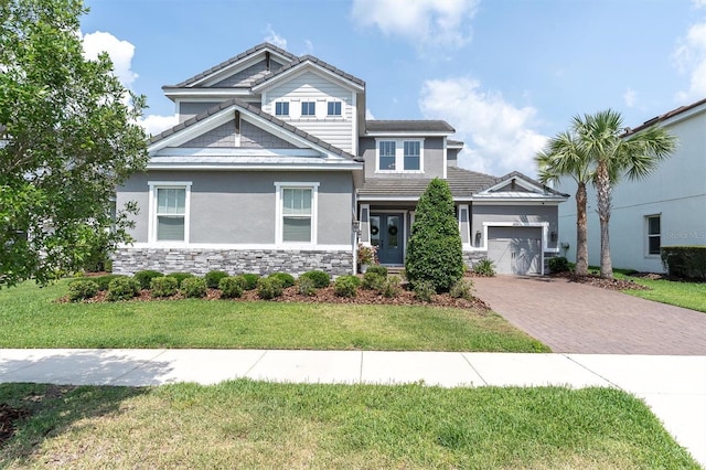 3850 Bonfire Dr, Odessa, FL 33556 - view of front of house featuring decorative driveway, a garage, stucco siding, a front lawn, and stone siding