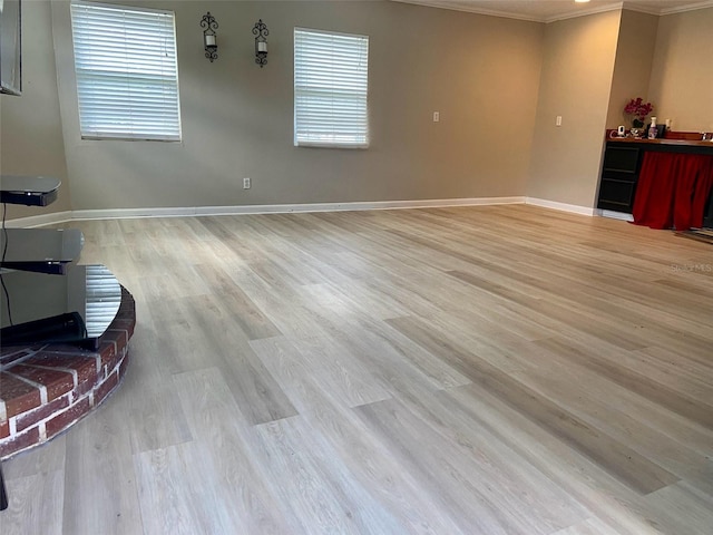 living room featuring ornamental molding, light wood-style flooring, and baseboards
