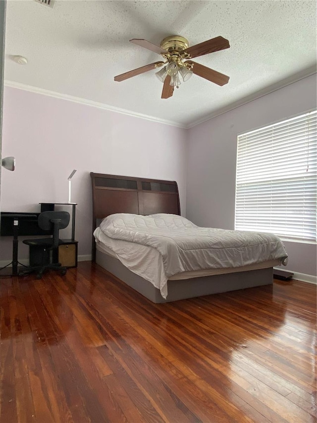 bedroom with hardwood / wood-style floors, crown molding, baseboards, and a ceiling fan