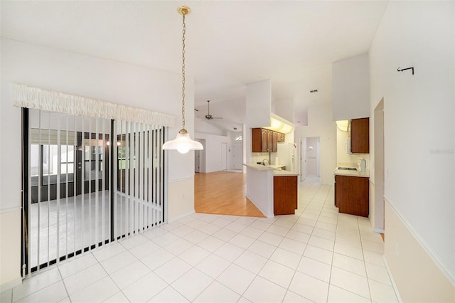 13819 Stoneridge Dr, Hudson, FL 34669 - kitchen with open floor plan, a ceiling fan, light countertops, brown cabinetry, and high vaulted ceiling