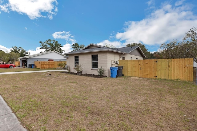 view of side of property with brick siding and a gate