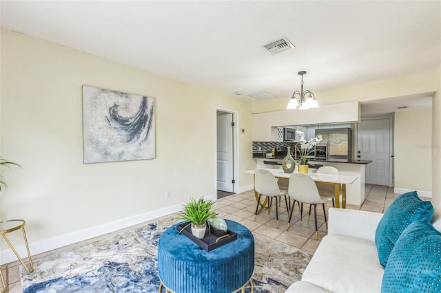 living area with a chandelier, light tile patterned floors, and baseboards
