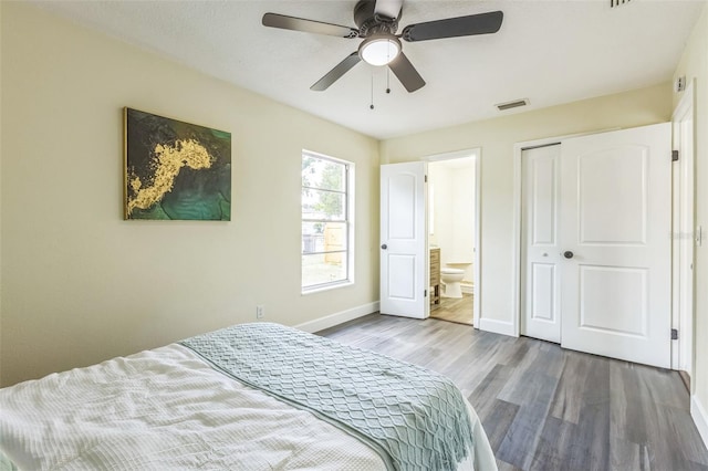 bedroom featuring wood finished floors, baseboards, a closet, ceiling fan, and connected bathroom