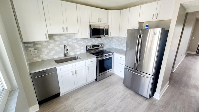 2205 Belleair Rd Unit A36, Clearwater, FL 33764 - kitchen featuring appliances with stainless steel finishes, a sink, light wood-style flooring, light countertops, and decorative backsplash