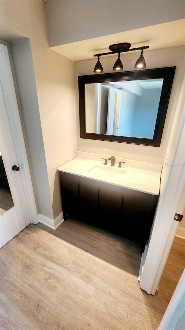 2205 Belleair Rd Unit A36, Clearwater, FL 33764 - bathroom featuring wood finished floors, baseboards, and vanity