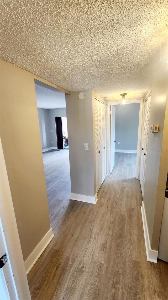 2205 Belleair Rd Unit A36, Clearwater, FL 33764 - hall with baseboards, a textured ceiling, and wood finished floors