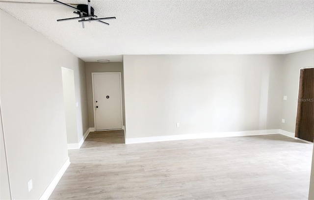2205 Belleair Rd Unit A36, Clearwater, FL 33764 - unfurnished room featuring light wood-style flooring, a textured ceiling, and baseboards