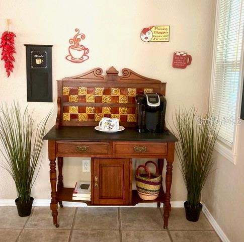 556 Virginia St, Dunedin, FL 34698 - bar area featuring baseboards and tile patterned flooring