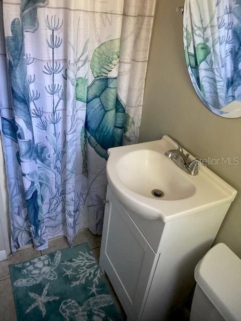 556 Virginia St, Dunedin, FL 34698 - bathroom featuring vanity, a shower with curtain, and toilet