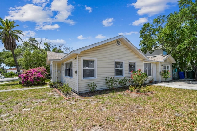 556 Virginia St, Dunedin, FL 34698 - ranch-style house with a front yard and a shingled roof