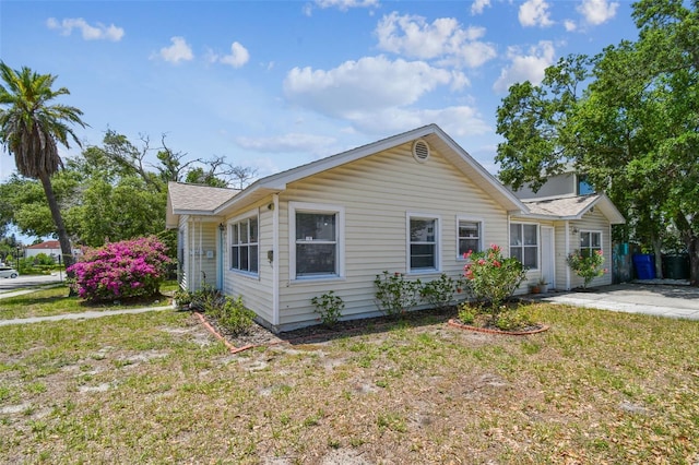 556 Virginia St, Dunedin, FL 34698 - ranch-style house with a front lawn and a shingled roof