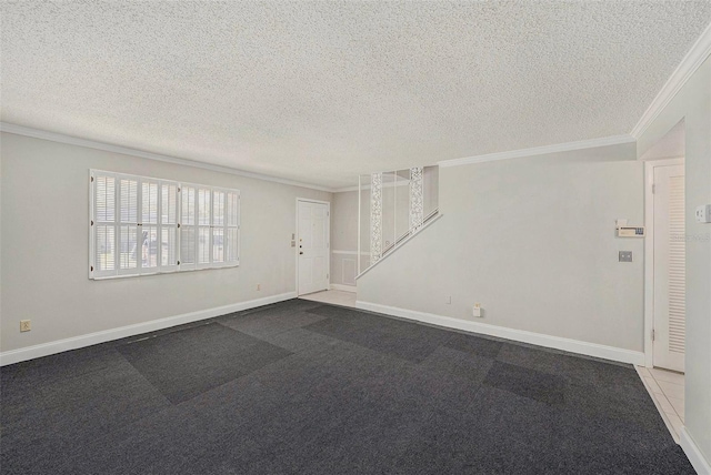 empty room featuring crown molding, a textured ceiling, baseboards, and carpet