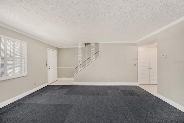 entrance foyer featuring ornamental molding, light colored carpet, a textured ceiling, baseboards, and stairway
