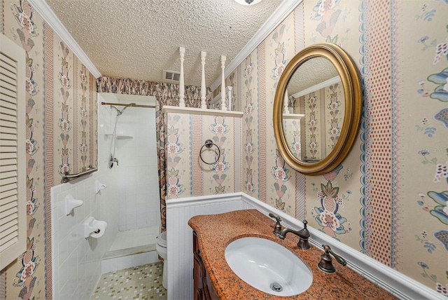 bathroom with crown molding, toilet, a textured ceiling, wallpapered walls, and a tile shower