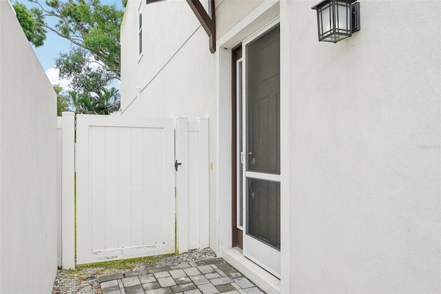 property entrance with a gate and stucco siding