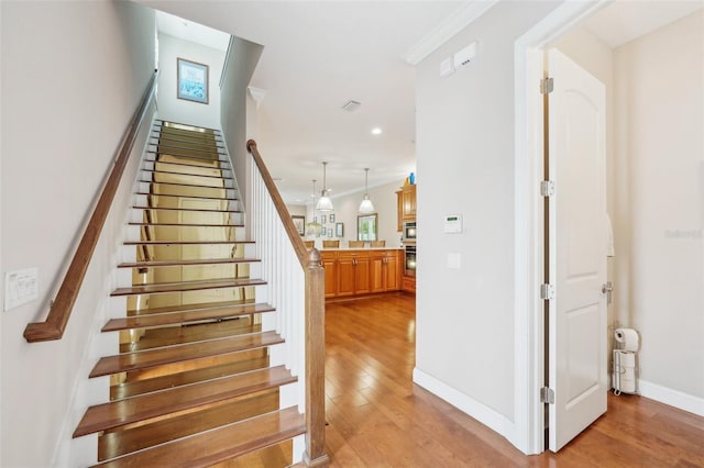 stairway featuring hardwood / wood-style floors, baseboards, and recessed lighting