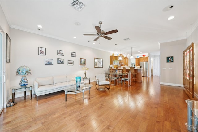 living room with ceiling fan, baseboards, recessed lighting, light wood finished floors, and crown molding