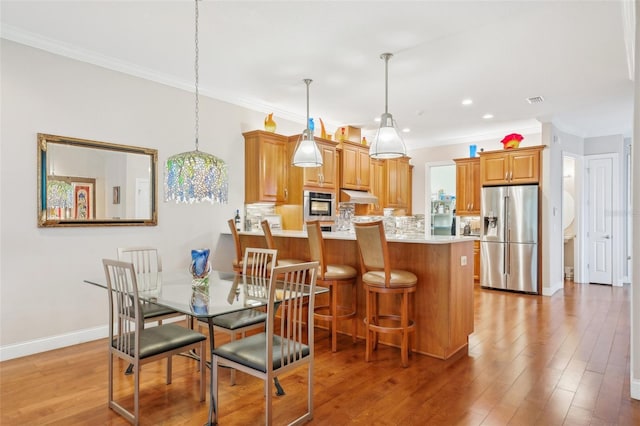 dining room with crown molding, light wood-style floors, baseboards, and recessed lighting