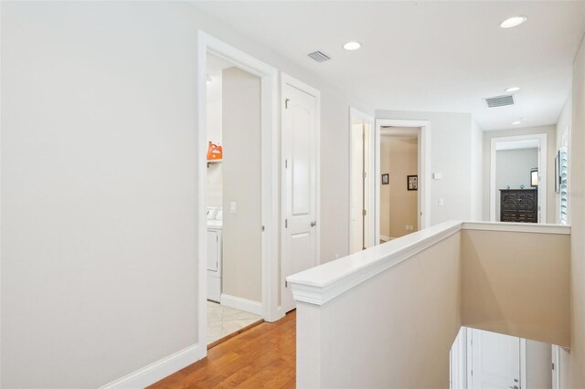 corridor with light wood-style flooring, recessed lighting, washer / clothes dryer, and baseboards