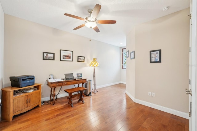 office space with ceiling fan, light wood-type flooring, and baseboards