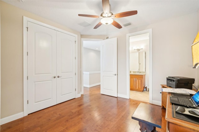 office with a ceiling fan, light wood-style floors, and baseboards