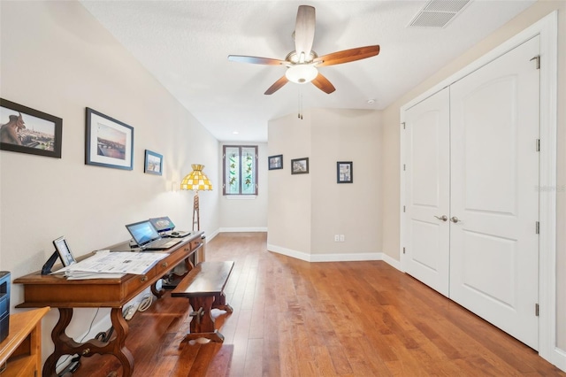 home office with ceiling fan, light wood-style flooring, and baseboards