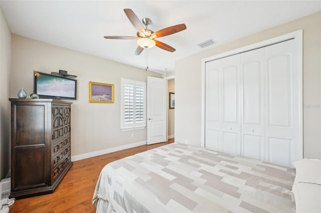 bedroom with wood finished floors, baseboards, a closet, and ceiling fan