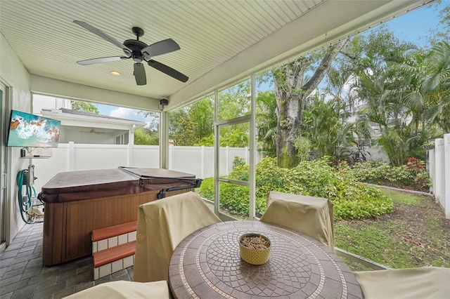 sunroom / solarium with a jacuzzi, ceiling fan, and outdoor dining space