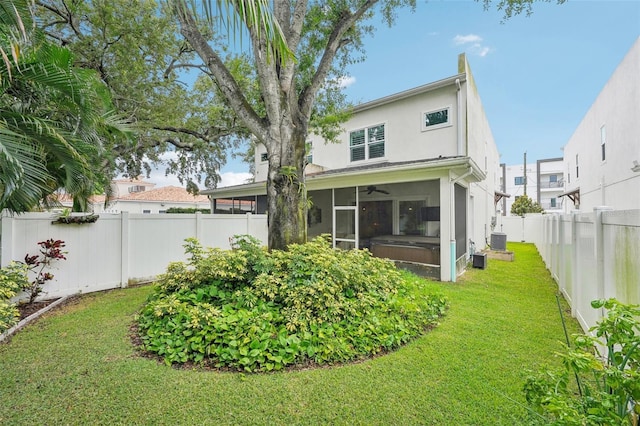 back of property with a sunroom, central air condition unit, ceiling fan, and stucco siding