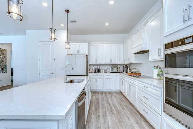 kitchen featuring stainless steel appliances, a sink, white cabinetry, an island with sink, and recessed lighting
