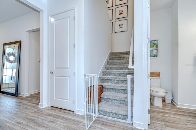 stairway featuring wood finished floors and baseboards