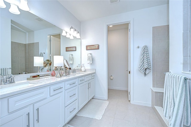 full bath with a walk in shower, double vanity, tile patterned flooring, and baseboards