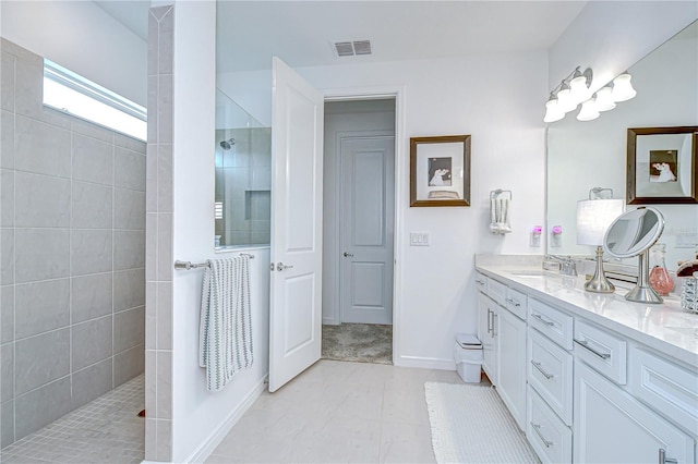 full bathroom with a walk in shower, vanity, baseboards, and tile patterned floors