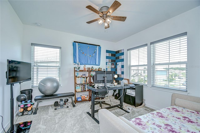 carpeted bedroom with a desk, baseboards, and ceiling fan