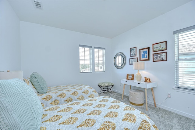 carpeted bedroom featuring multiple windows and baseboards