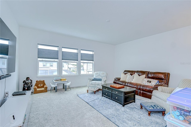carpeted living area featuring baseboards