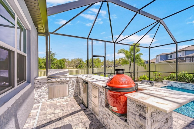 view of patio / terrace with area for grilling, a lanai, and fence