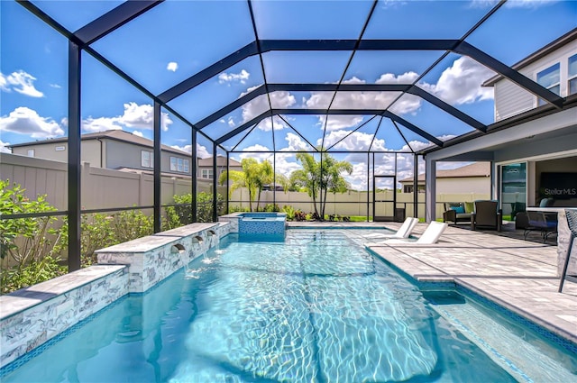 view of swimming pool with a patio area, a pool with connected hot tub, a lanai, and fence
