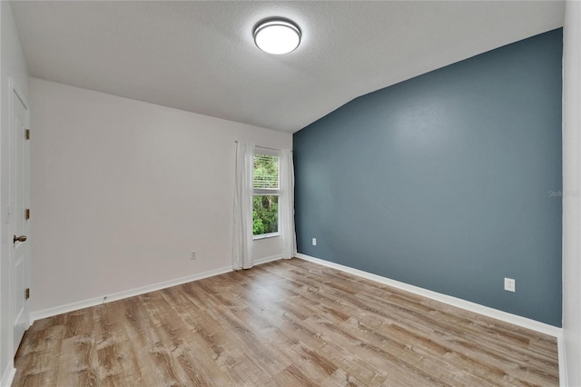 15855 Fishhawk View Dr, Lithia, FL 33547 - unfurnished room featuring lofted ceiling, wood finished floors, baseboards, and a textured ceiling