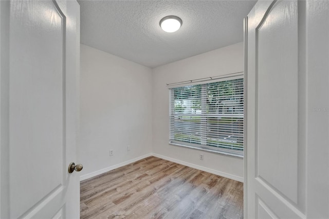 15855 Fishhawk View Dr, Lithia, FL 33547 - spare room featuring a textured ceiling, wood finished floors, and baseboards