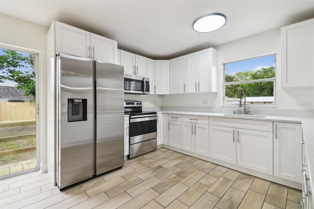 1801 E Navajo Ave, Tampa, FL 33612 - kitchen with appliances with stainless steel finishes, a sink, light countertops, and white cabinets