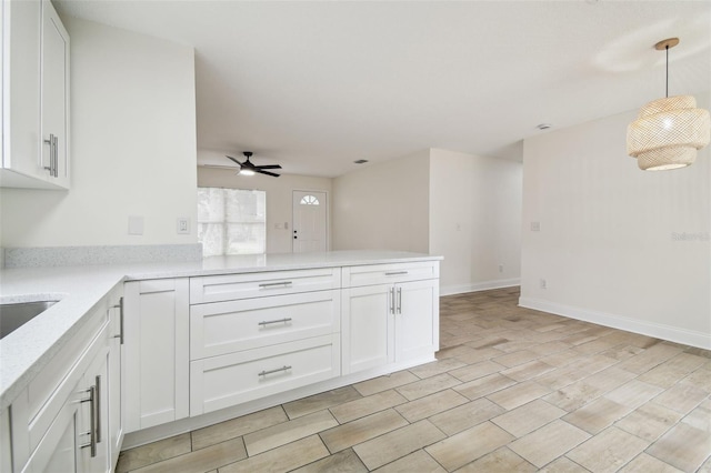 1801 E Navajo Ave, Tampa, FL 33612 - kitchen featuring ceiling fan, white cabinets, a peninsula, and hanging light fixtures