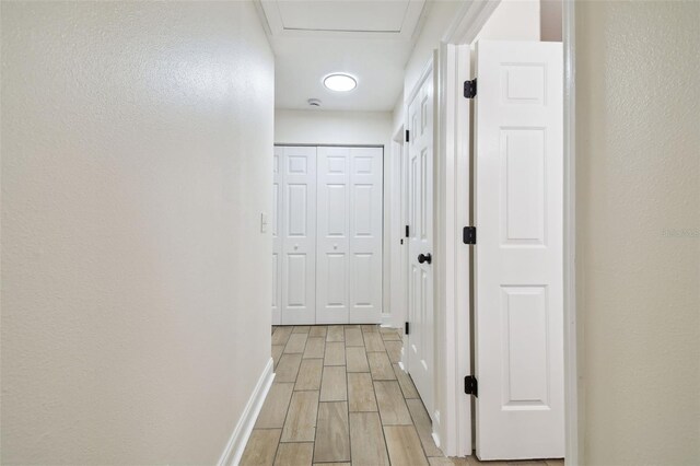1801 E Navajo Ave, Tampa, FL 33612 - hallway featuring wood tiled floors, baseboards, and attic access