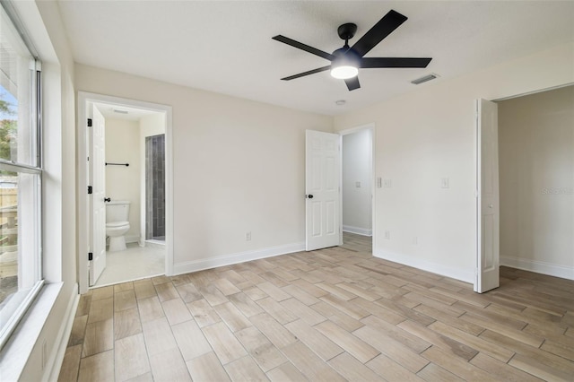 1801 E Navajo Ave, Tampa, FL 33612 - unfurnished bedroom featuring light wood finished floors, baseboards, connected bathroom, and ceiling fan